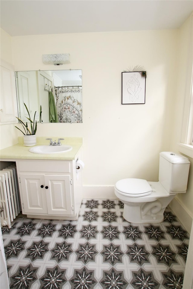 bathroom with radiator, vanity, and toilet