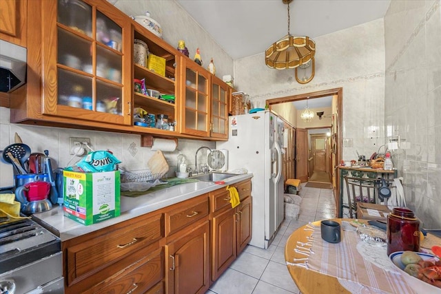 kitchen featuring sink, tile walls, decorative light fixtures, light tile patterned flooring, and stainless steel appliances