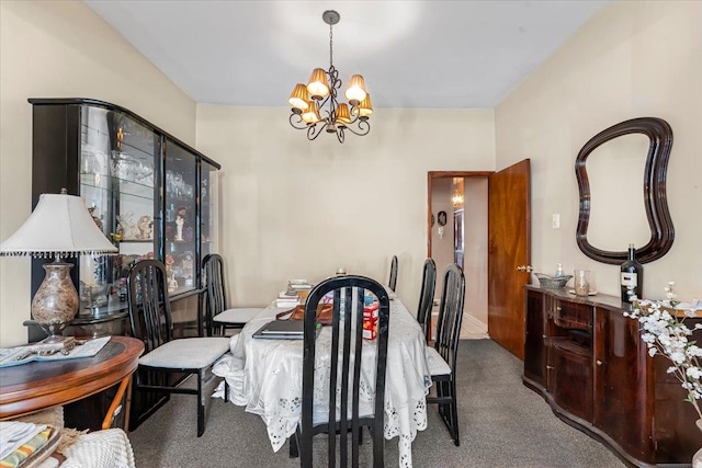 dining room with carpet floors and a chandelier