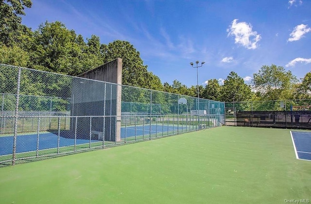 view of tennis court with basketball hoop