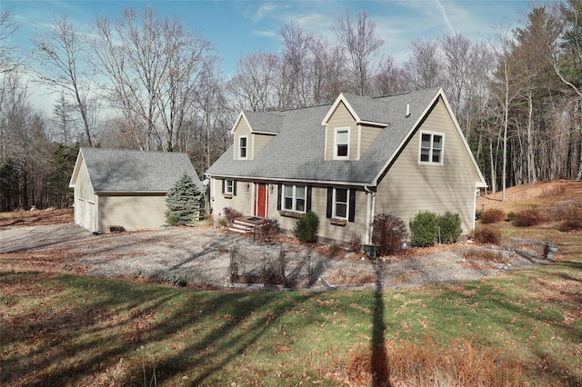 cape cod-style house featuring an outbuilding and a front yard