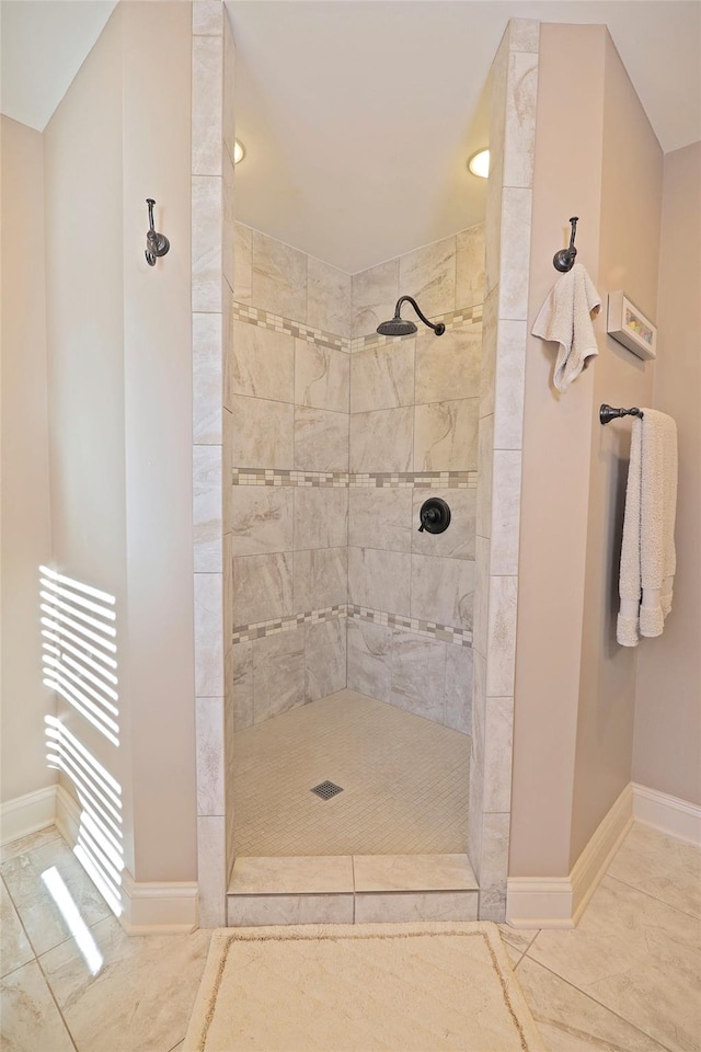 bathroom with tiled shower and tile patterned floors