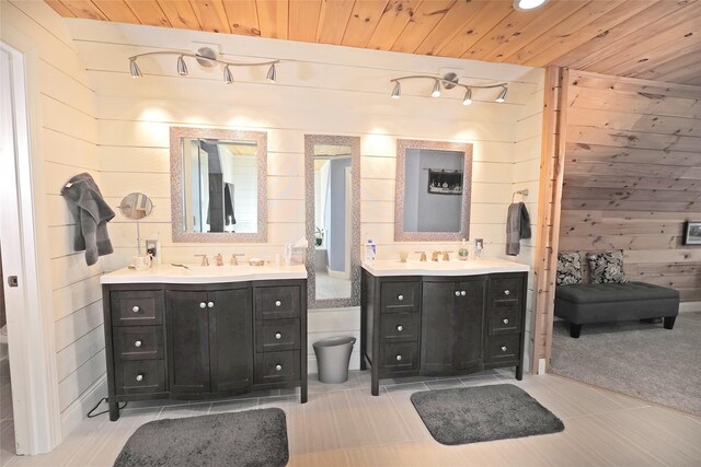 bathroom featuring tile patterned flooring, vanity, wooden walls, and wood ceiling