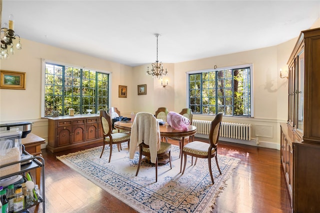 dining area featuring radiator heating unit, an inviting chandelier, and dark wood-type flooring