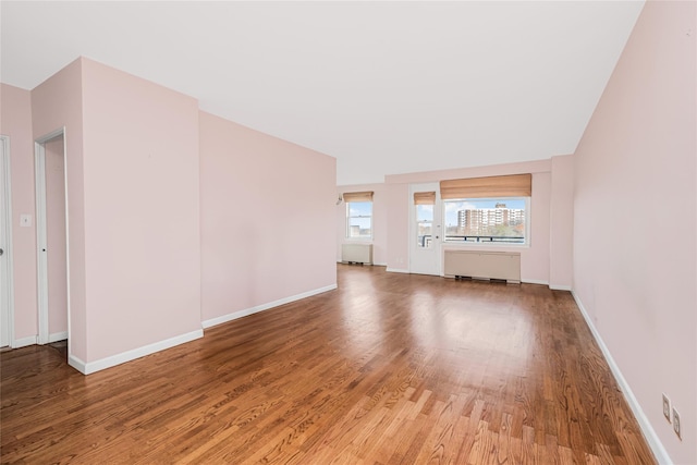 unfurnished living room with wood-type flooring and radiator