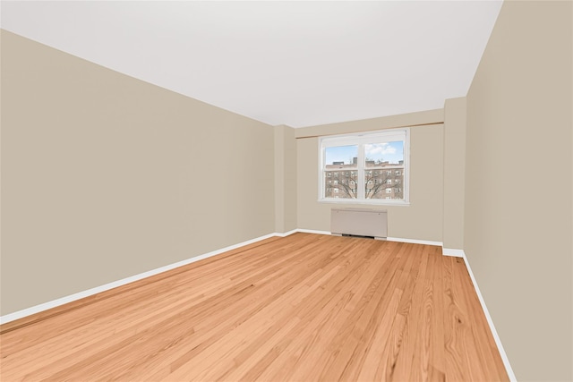 spare room featuring light hardwood / wood-style floors and radiator