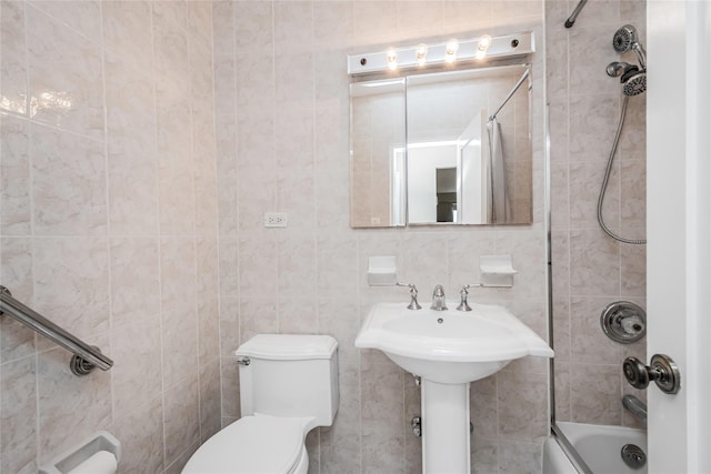 bathroom featuring toilet, tile walls, and tiled shower / bath