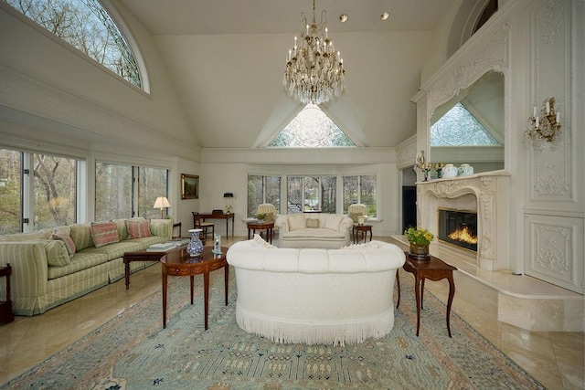 living room featuring a fireplace, high vaulted ceiling, and a chandelier