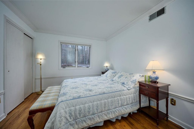 bedroom with dark hardwood / wood-style floors, a closet, and ornamental molding