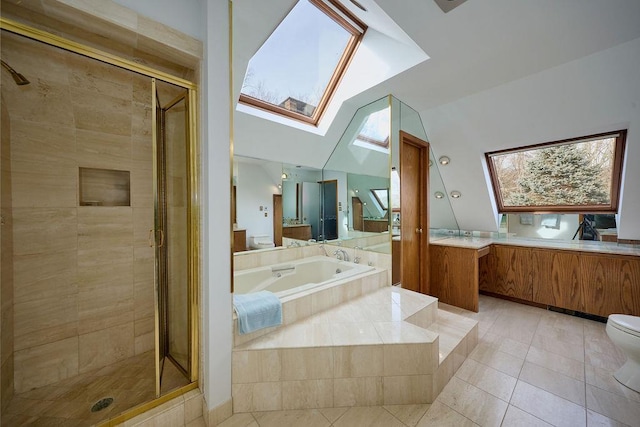 full bathroom featuring tile patterned floors, toilet, vaulted ceiling with skylight, and independent shower and bath