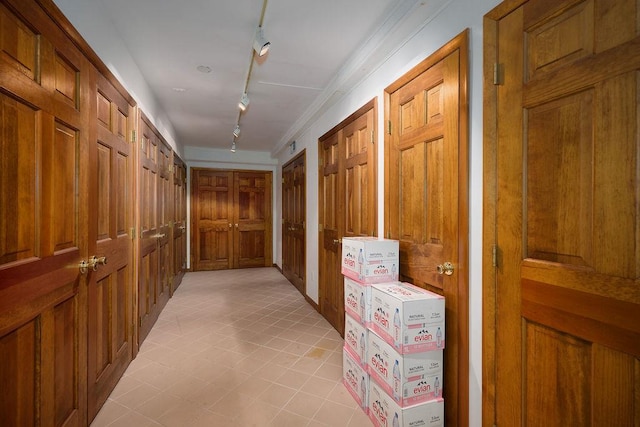 hall featuring ornamental molding and rail lighting