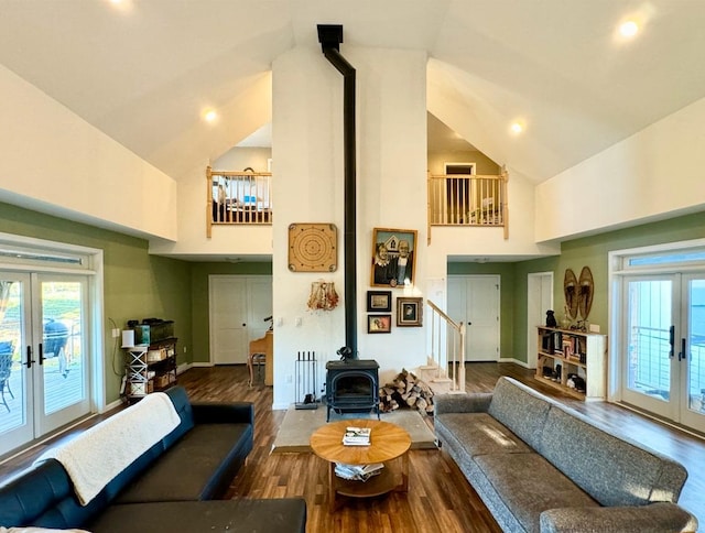 living room featuring a wood stove, french doors, high vaulted ceiling, and hardwood / wood-style flooring