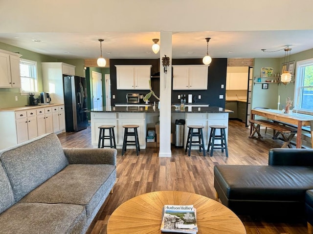 living room with plenty of natural light and dark hardwood / wood-style flooring