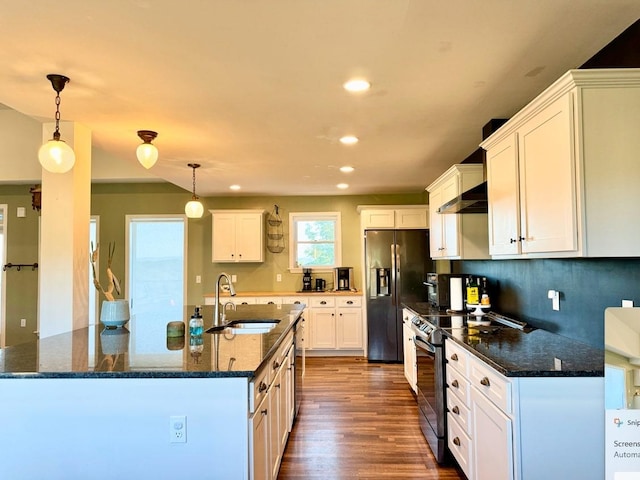 kitchen with wall chimney exhaust hood, white cabinetry, hanging light fixtures, and appliances with stainless steel finishes