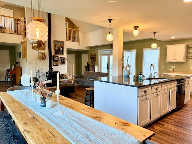 kitchen with white cabinetry, sink, an island with sink, and decorative light fixtures