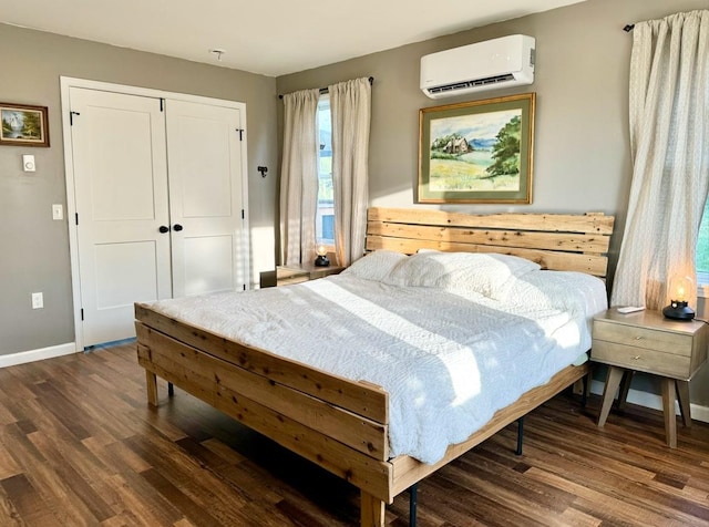 bedroom featuring a wall mounted AC, a closet, and dark hardwood / wood-style floors