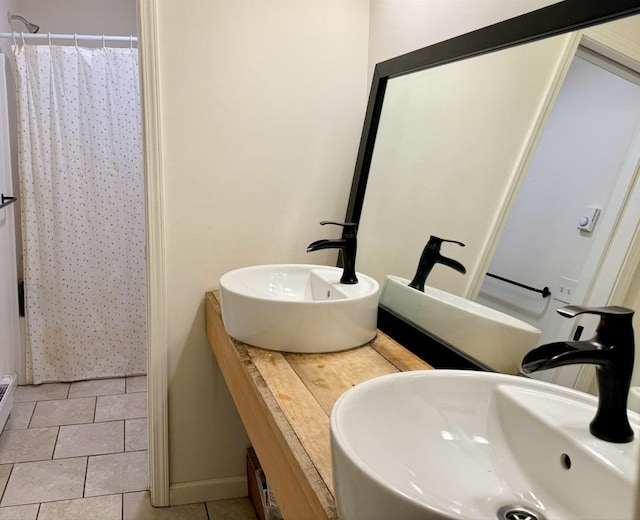 bathroom with tile patterned flooring, vanity, and walk in shower