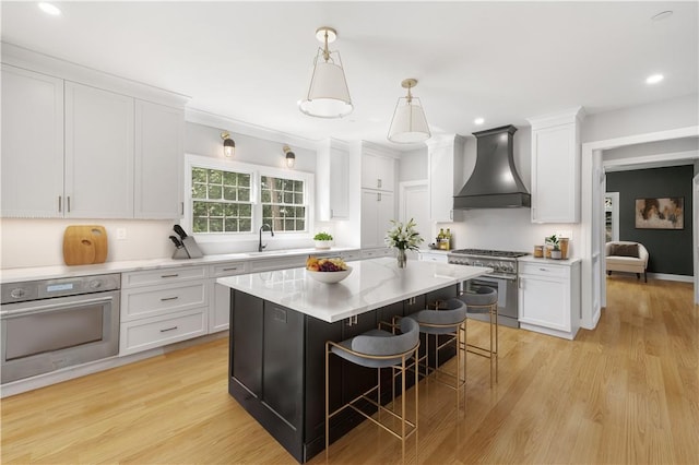 kitchen featuring stainless steel appliances, a kitchen island, white cabinetry, custom exhaust hood, and pendant lighting