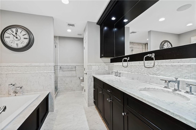 bathroom featuring visible vents, a sink, toilet, and double vanity