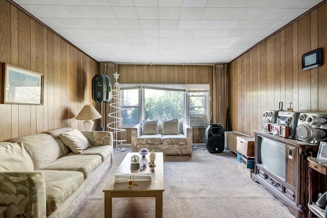 living room featuring wood walls and light colored carpet