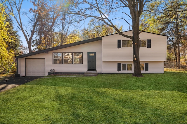 split level home with a garage and a front lawn