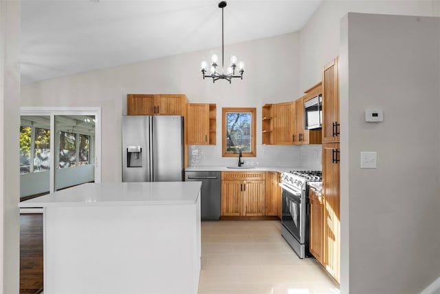 kitchen featuring lofted ceiling, sink, decorative light fixtures, appliances with stainless steel finishes, and a notable chandelier