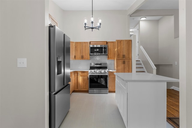 kitchen with decorative light fixtures, tasteful backsplash, stainless steel appliances, and a chandelier