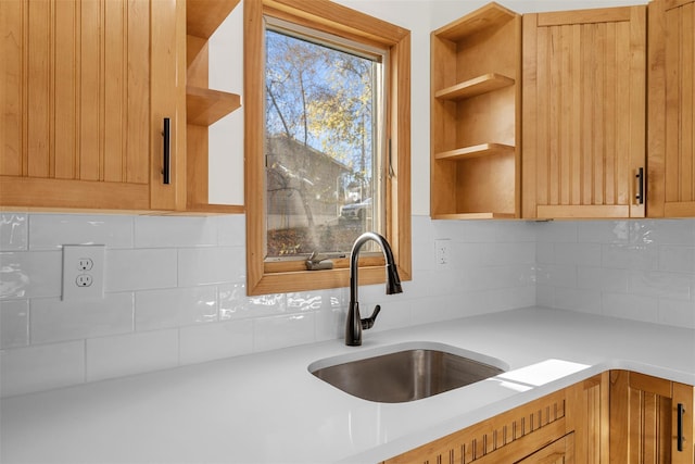 kitchen featuring light brown cabinets, sink, and tasteful backsplash