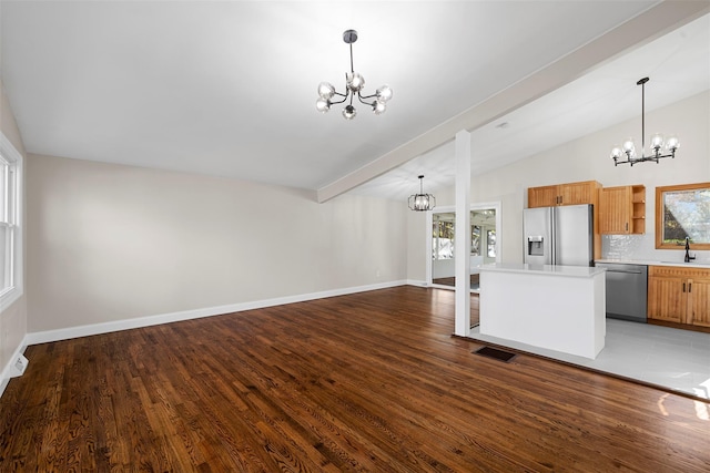 unfurnished living room with dark hardwood / wood-style flooring, an inviting chandelier, lofted ceiling with beams, and sink