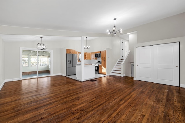 unfurnished living room with wood-type flooring, an inviting chandelier, and lofted ceiling