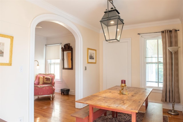 dining area with wood-type flooring and ornamental molding