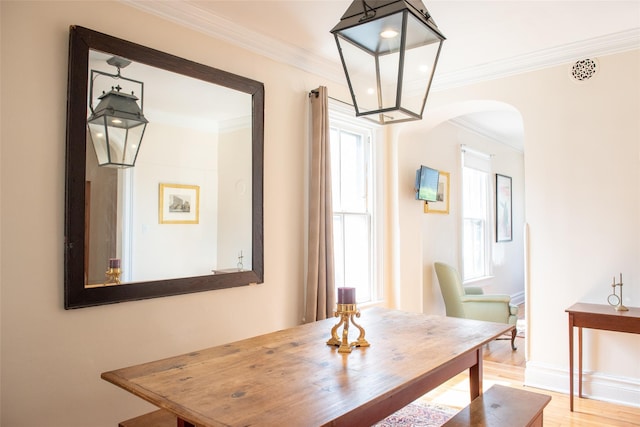 dining space with hardwood / wood-style floors, a wealth of natural light, and ornamental molding