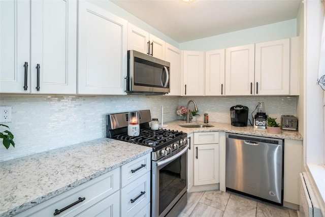 kitchen with decorative backsplash, sink, white cabinetry, and stainless steel appliances