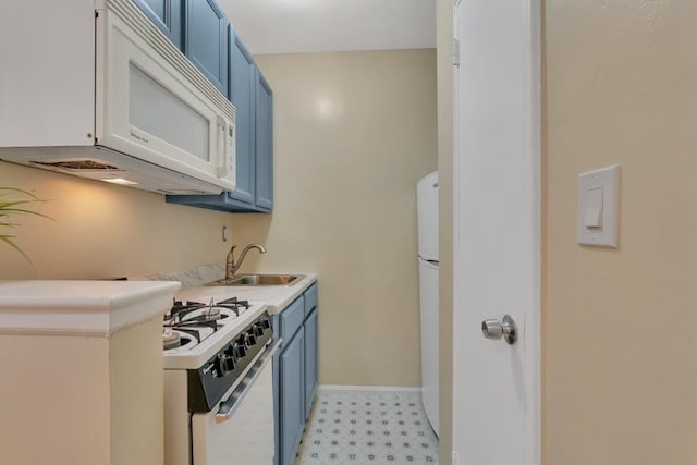 kitchen featuring blue cabinetry, sink, and white appliances