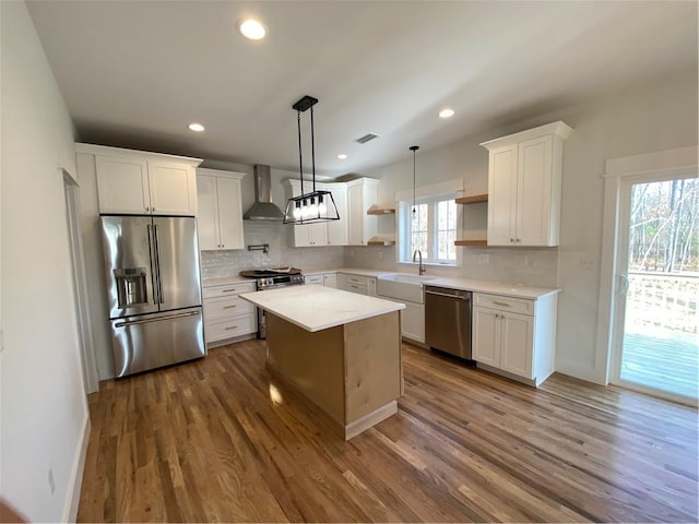 kitchen featuring white cabinetry, wall chimney exhaust hood, dark wood-type flooring, and appliances with stainless steel finishes