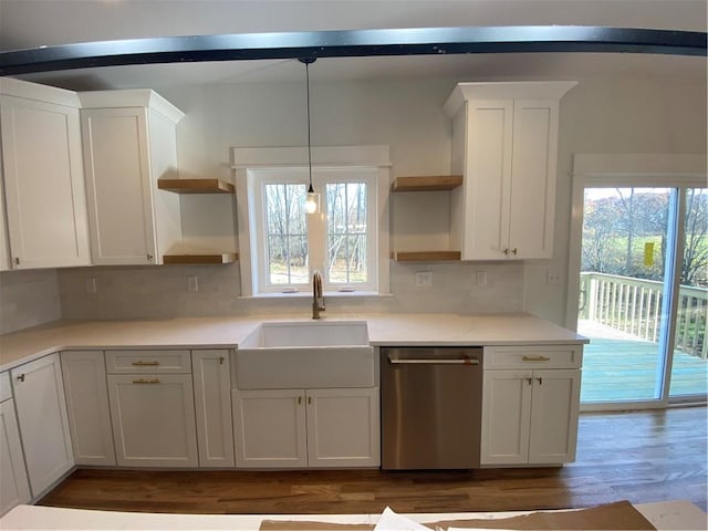 kitchen with dishwasher, decorative light fixtures, light countertops, open shelves, and a sink