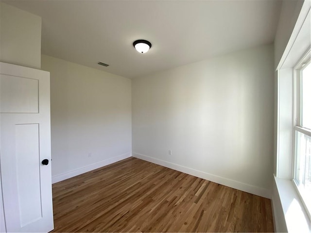 spare room featuring dark wood-style floors, baseboards, and visible vents