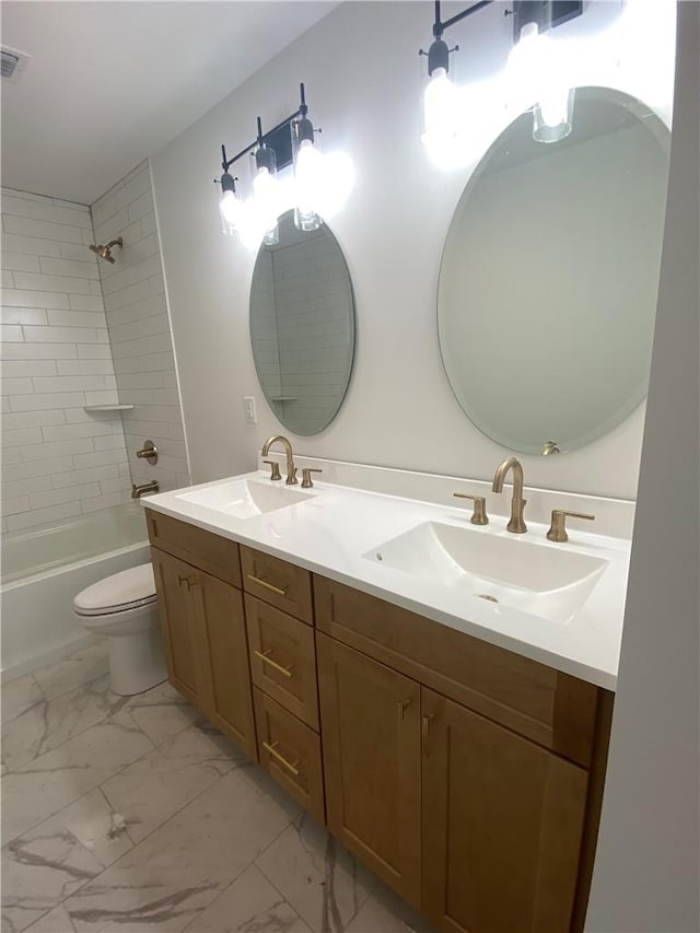 full bathroom featuring tiled shower / bath combo, toilet, and vanity