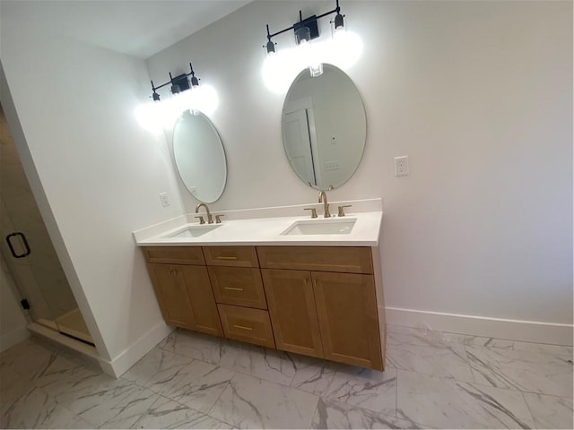 full bath featuring marble finish floor, double vanity, a sink, and baseboards