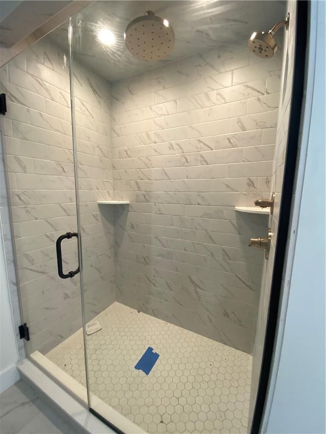 full bath featuring marble finish floor and a shower stall