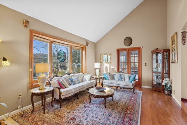 living room featuring hardwood / wood-style flooring, high vaulted ceiling, and french doors