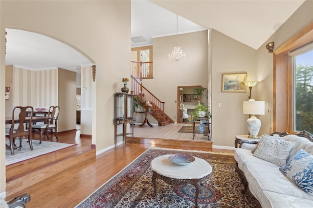 living room with hardwood / wood-style floors, high vaulted ceiling, and a chandelier