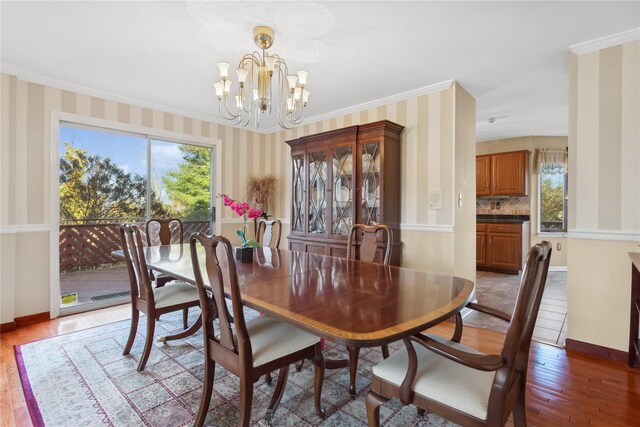 dining room featuring a notable chandelier, ornamental molding, and dark wood-type flooring