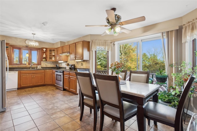 kitchen featuring sink, hanging light fixtures, decorative backsplash, ceiling fan with notable chandelier, and appliances with stainless steel finishes