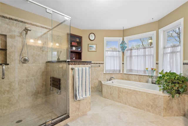 bathroom with tile patterned floors and shower with separate bathtub