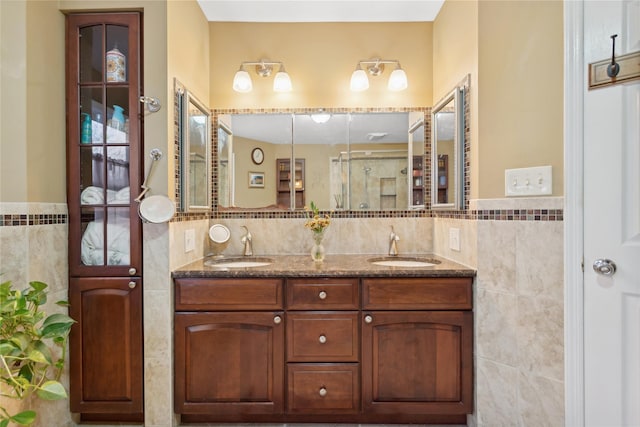 bathroom featuring vanity, a shower with door, and tile walls