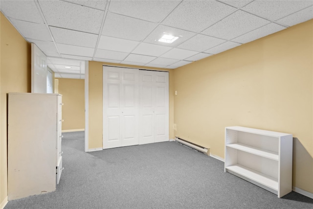 unfurnished bedroom with carpet flooring, a paneled ceiling, a closet, and a baseboard radiator