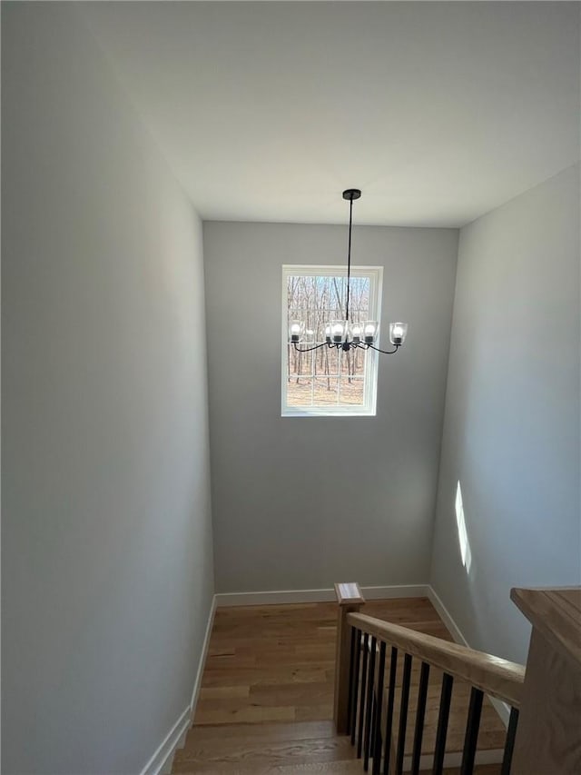 stairway featuring a chandelier and wood-type flooring