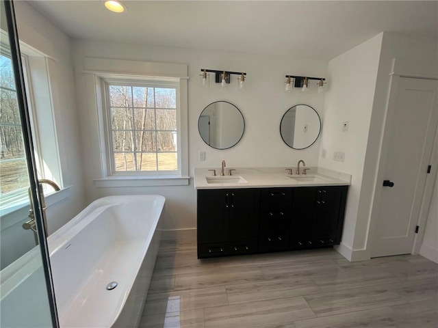 bathroom featuring hardwood / wood-style floors, vanity, and a tub