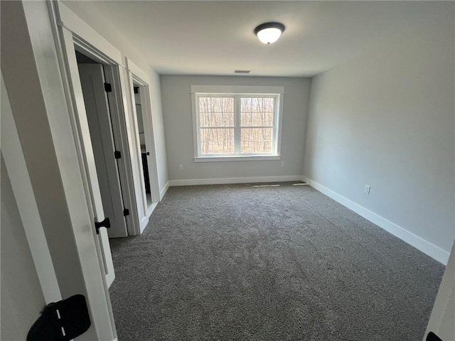 spare room with dark carpet